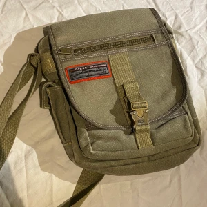 Diesel väska - Jättesnygg Diesel crossbody väska! Den har välsigt många olika fack och remen är justerbar. Finns några märken på baksidan osv men inget brutalt. Har ett jättesnyggt ”alyx” spänne. Skriv för fler bilder eller andra funderingar ❣️