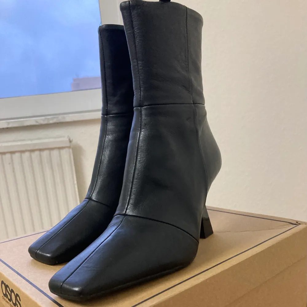 Super snygga svarta boots med fyrkantig tå från ASOS i 100% äkta läder! Jätte trendiga just nu och passar till allt! Oanvända och skickas i originalbox. Säljer eftersom de tyvärr sitter lite tajt på mig.  (Nypris 1300kr). Skor.