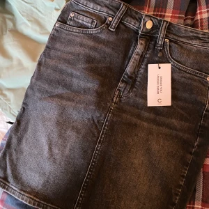 Grå kjol - Halvlång kjol, lapparna kvar så aldrig använd. Nypris 300 Mitt pris 100