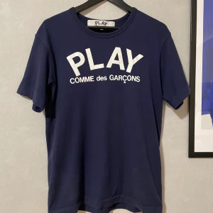 Play Cdg T-shirt  - Köpt på Paul and friends på Nk i Stockholm i våras för 1000kr. Storleken är L men sitter mer som en M, Då den krymper lite i den första tvätten.  Fint skick, inga fläckar eller hål   Kvitto finns  Pris: 700kr     