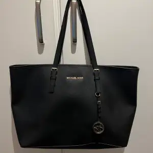 Michael Kors väska i fint skick! Svart med gulddetaljer. Stl: l38xb15xh30cm. Många fack som tex datorfack inuti. Köparen betalar ev frakt. 