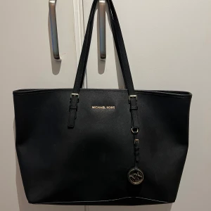 Michael Kors väska - Michael Kors väska i fint skick! Svart med gulddetaljer. Stl: l38xb15xh30cm. Många fack som tex datorfack inuti. Köparen betalar ev frakt. 