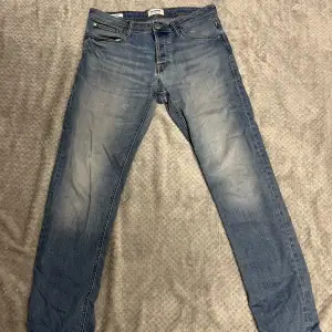 Slitna jeans ifrån Jack & Jones med storlek W32 L32. Missfärgning vid ens fickan samt ett hål vid mellan benen. 
