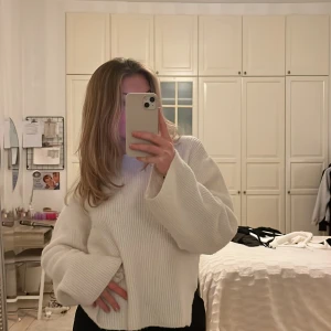 Stickad tröja  - Vit stickad tröja med långa och vida ärmar, med liten slits på båda sidor. Från chiquelle!