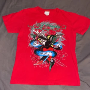 Ed Hardy t-shirt - Säljer denna jättecoola röda Ed Hardy tröjan i strl M. Skriv privat om ni vill köpa, har några frågor eller vill ha fler bilder. Jag kan posta paketet om köparen betalar frakten eller mötas i Stockholm. 😊