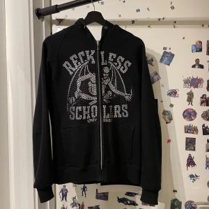 Reckless Scholars ziphoodie  - En nästan helt oanvänd ziphoodie från en av reckless scholars kollektioner. Kommer med original påse.  Säljer denna nu pga för lite användning. 10/10 fräshenheter! Om ni vill ha fler bilder eller har några frågor, hör av er! 