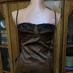 Brun silke klänning  - Tunnt material med svart spets på bysten. Oanvänd