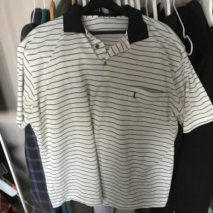 YSL Pike vintage - En YSL piké vintage, i ”sport”material typ nylon. Lite kaffefläck som säkert går bort med vanish. Sitter perfa på mig som e 190, den är XXL men skulle mer säga att den är som en XL. (Herr)