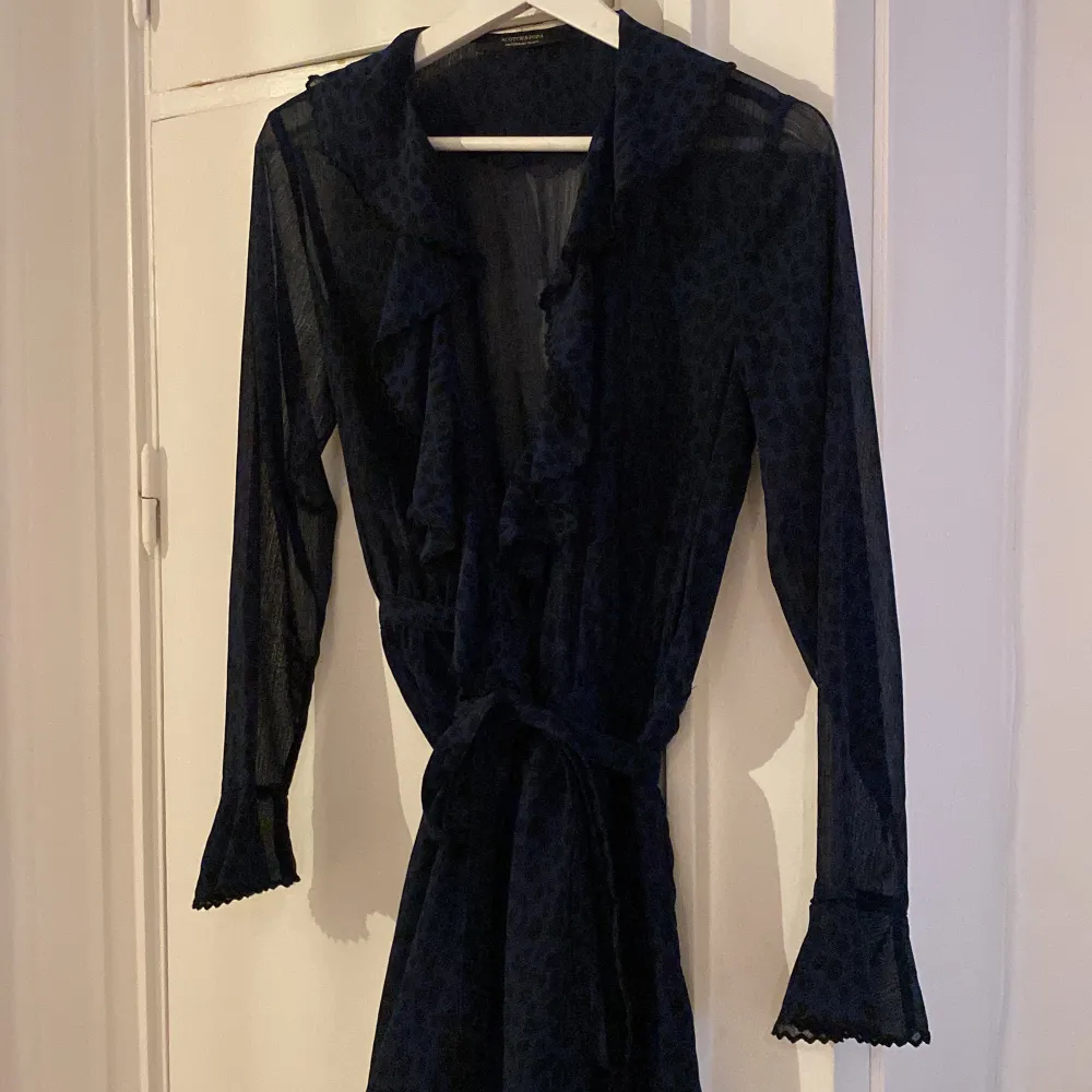 Mörkblå mönstrad sheer wrap klänning med volang detaljer från Scot  ch and Soda. Bra skick . Klänningar.