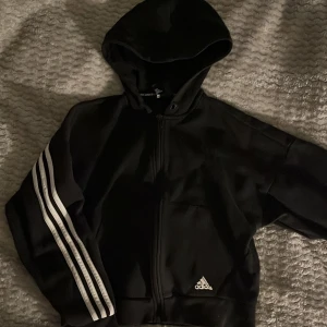 Adidas zip hoodie - En super bekväm svart ziphoodie från adidas i gott skick. Den är i storlek XS men passar även S, köpt för 500kr och säljs för 199kr+frakt. Kontakta gärna mig för mer detaljer eller diskution om priset. Köparen står för frakten 