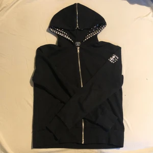 Hoodie - Ascool, svart hoodie i en liten kortare modell med fina detaljer i t.ex luvan. Köpt secondhand men ser helt oanvänd ut!