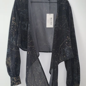 NAKD blus, strl 42 - Oanvänd blus från NAKD, storlek 42. Wrap blus som är tunn, långa snören så man kan knyta flera varv eller ha långa hängandes. frnsqr i ändarna på snörena.