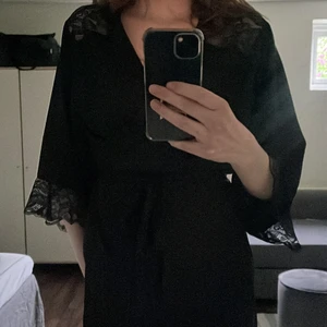 Svart morgonrock i satinmaterial - Svart morgonrock i satinmaterial från H&M i storlek XS/S. Superfin och nästan oanvänd! Frakten ingår ej i priset för plagget!