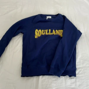 Soulland Sweatshirt - Knappt använd snygg mörkblå sweatshirt från märket soulland med stilrent tryck på bröstet. Tröjan är sydd med lite texturers tyg på sidorna se bild. Storlek L men sitter ganska smalt å hade passat utmärkt på M och kanske S också!