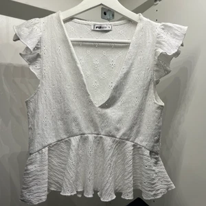 Vit volangtopp - Säljer denna superfina volangtopp!! Perfekt inför sommaren🌟🌟endast testad🌟🌟köpt förra året, nypris 299kr. 