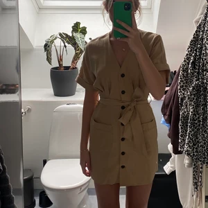 Beige klänning  - En mörk beige klänning med svarta knappar med tillhörande band från Zara. Antingen kan man ha klänningen som den är eller så knyter man bandet i midjan. Jag bär storlek S och är 171 cm lång men funkar även för dem som bär storlek XS. 