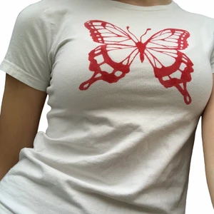 Vit T-shirt med rött fjärilstryck - Superfin vit t-shirt med en röd fjäril målad på. Har målat på trycket själv med tyfärg som inte går bort i tvättat. T-shirten är originellt från polarn o pyret, storlek 146/152, men den passar jättebra på mig som brukar ha S/M.  Skriv för fler frågor. Köparen står för frakt❤️