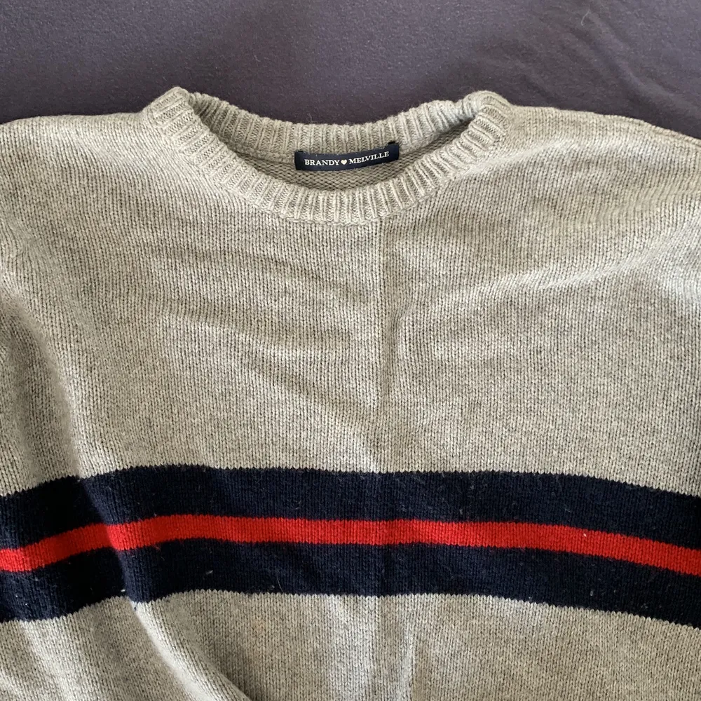 En grå stickad tröja med blåa och röda ränder. Den passar som en xs-s. Tröjor & Koftor.