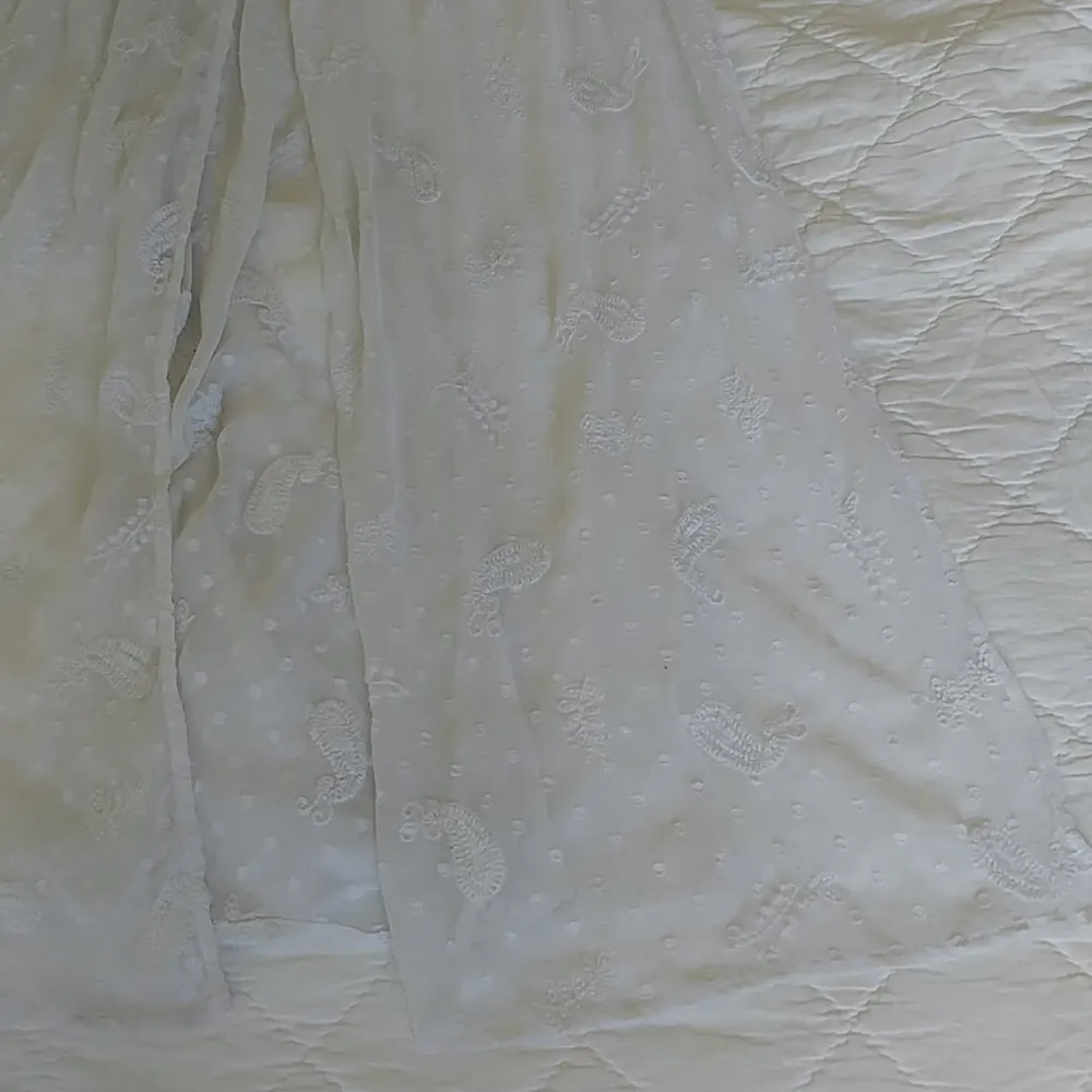 En vacker klänning i vit spets med broderat Paisley-mönster. Passar en S-M.. Klänningar.