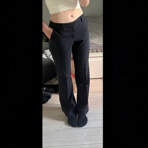 Lågmidjade kostymbyxor  - Svarta lågmidjade kostymbyxor från Filipa i K. Endast använda en gång. Storlek L, men sitter mer som m/s. Köpta för 2100kr. Visar många intresse blir det budgivning som startar på 400. Hör av er för fler frågor och bilder🥰