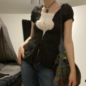 Vintage topp - Säljer denna söta svartvita topp med lite 2000’s vintage vibe. Det svarta tyget är fastsytt ovanpå det vita. Vanligtvis brukar jag gilla att knäppa igen det svarta materialet med en säkerhetsnål, men den riktiga passformen redovisas på bild 3💕