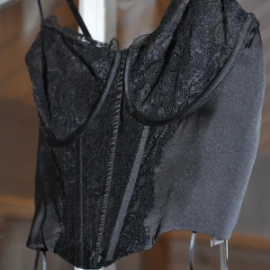 Spets korsett topp - Helt ny, endast provad, svart korsett topp i spets från stradivarius. I storlek S. Justerbara axelband. Finns två olika krokar i ryggen (likt en bh) så den går även att justera i själva måttet runt. Slutsåld på hemsidan.