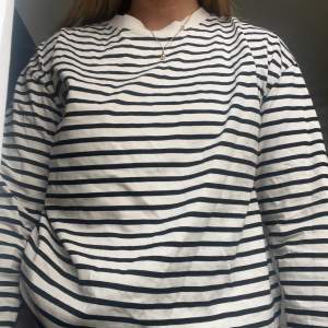 Randig långärmad tröja från Gina Tricot som går i det beiga/vita hållet med svarta ränder. 