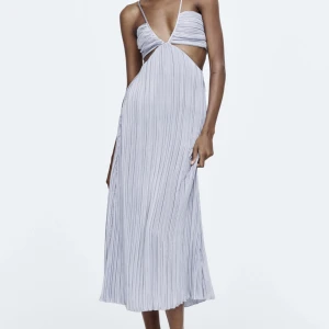 Plisserad klänning  - Jag säljer denna superfina klänning  från Zara. Den är ljusblå plisserad och man knyter den där bak! Slutsåld på deras hemsida & helt oanvänd. Nypris: 699 kr