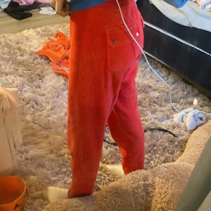 Orange/röd juicy byxor - Ett par jättefina orange/röda juicy byxor i gammal modell, jag säljer för att de är för korta, endast prövade, bra skick, inga fläckar, köparen står för frakten och jag tvättar innan jag skickar, byxorna är i storlek s men passar även xs och xxs 
