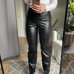 Straight PU Pant Nelly  - PU byxor från Nelly använda en gång. Långa och raka i modellen. Resår i midjan och går ner till fötterna på mig som är 175,5 cm. Riktigt bekväm byxa som är otroligt snygg och stilren för antingen en utekväll eller med en stickad tröja till vardags. Nypris 399kr
