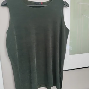 Vintage linne i skimrande mörkgrön färg  - Ett unikt vintage linne med en lätt skimrande mörkgrön/mossgrön färg. Riktigt fint! Enkelt men ändå festligt! Storlek M/L.