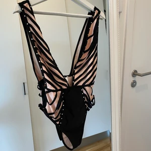 Ny baddräkt  - Oanvänd baddräkt. Svart/rosa med stenar. Storlek 36. Pris: 150kr + frakt 52kr.