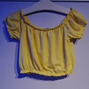 Gul somrig crop topp - Säljer denna gula somriga topp då den är för stor för mig. Toppen är köpt från gina tricot och är i storlek M. Man kan ha den både off shoulder och som på bilden. Kontakta vid intresse <3
