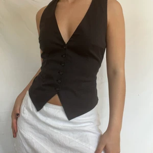 Svart pinstripe väst - Underbar kostymväst med tunna ränder. Justerbar i ryggen så bör passa allt mellan s-m. Jag själv bär oftast S i toppar. Köpare står för 51kr spårbar frakt. Plagget är i gott defetfritt skick. 