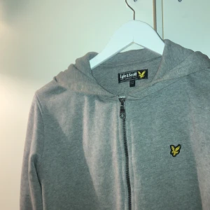lyle&scott hoodie med dragkedja - Basic men snygg grå hoodie med dragkedja. Ser ut exakt som ny. Säljes då den inte kommer till användning hos mig.