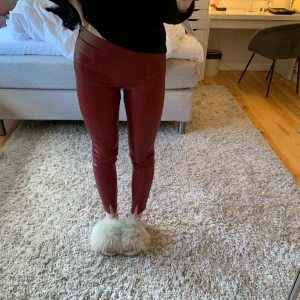 Röda Läderbyxor från Zara - Vinröda / mörkröda läderbyxor från Zara. Tighta med en slit vid foten. Bra festplagg.