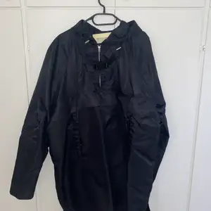Alyx oversized rain pullover in Size L in black. In amazing condition. Features front pocket below the buckle. Only worn a handful of times. Comes with tags, sold out everywhere. Retail price is 4,488 SEK.Will ship out the same or next day.