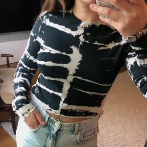 Batikmönstrad topp - Batikmönstrad svart/vit topp i croppad modell från Weekday. Storlek M, stretchigt tyg. Köparen står för frakten.