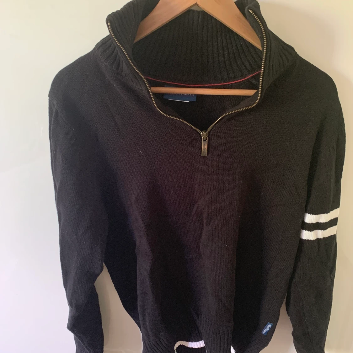 Långärmad tröja med dragkedja vid halsen och hög hals.