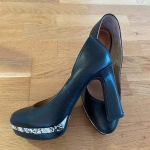 Svart pumps i läder med hög klack - Svart pumps i läder storlek 36. Klackhöjd 9cm. Märke Belle. Fint skick. Hämtas vid Kungsholmen eller Globen. Alt skickas mot frakt. 