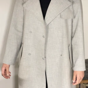 Unik grå trenchcoat  - Fin gråmelerad trenchcoat i gott skick. 
