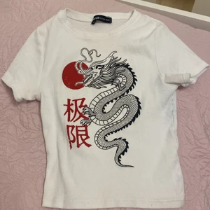 Vit topp med drake design  - Vit topp med en drake på, från Newyorker. Storlek xxs, väldigt stor.