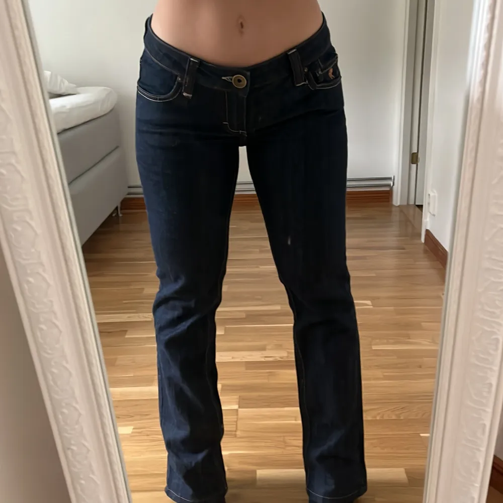 mörkblåa lågmidjade jeans med snygga detaljer på rumpan. raka i modellen och nästan helt nya!! innerbenslängd: ca 72cm, midjemått: ca 37cm. Jeans & Byxor.