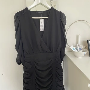 Svart klänning  - Helt oanvänd klänning från Gina Tricot, mesh ärmar och slimmad nedtill. Knyten längs ner men endast som assessoar. Den är lite för liten för mig så inte kunnat använda
