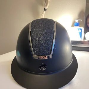 Super fin ridhjälm - Super fin glittrig ridhjälm i st 52/54. Som ny! Inga repor eller missfärgningar säljer då den inte passade mig.