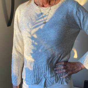 Tröja - Superfin ljusgrå stickad tröja med fint mönster nertill och på ärmarna ( dragkedja i ryggen) 