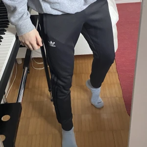 Gråa Adidasbyxor  - Väldigt fint skick, inte använt så mycket. Tre svarta sträck längst benet och adidasmärket på ena benet. Köparen står för frakt. 