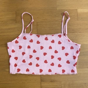 Croptop med hjärtan - Justerbara band. Väldigt stretchig. Passar S-XL (kanske lite lös om man brukar ha S och lite tight om man brukar ha XL), jag brukar ha M på överdelar och det sitter bra/lite löst på mig. Använt kanske 3-4 ggr. 