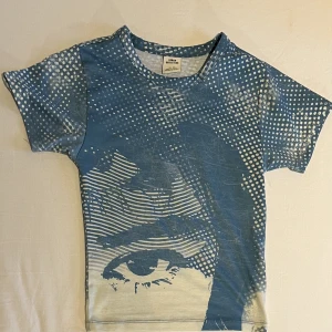 Baby tee grafiskt tryck Urban Outfitters - Sparsamt använd, i nyskick. Köpt sommaren 2022, originalpris 349kr. Säljer även jeansen från bilden i en separat annons :)