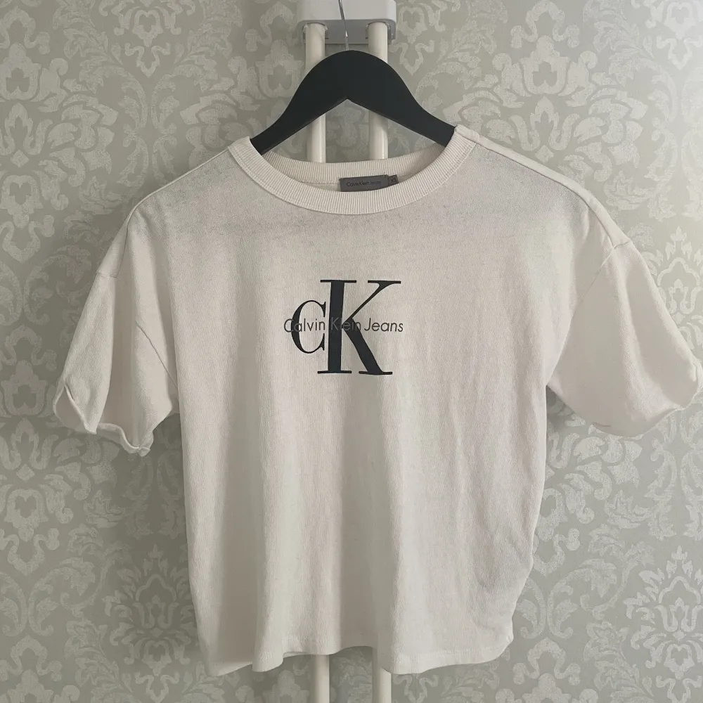 Ikonisk vit t-shirt 100% bomull med vintagekänsla från CK butik i Amsterdam. Löst uppvikta ärmar. Sömmen har släppt på insidan bak, enkelt att fixa, se bild.. T-shirts.